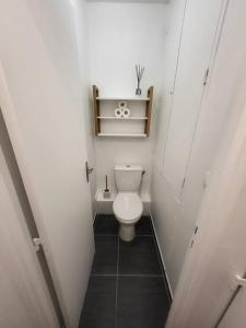 Elle comprend une petite salle de bains pourvue de toilettes et d'une étagère. dans l'établissement Pépite entre Paris et Versailles, à Chaville
