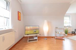sala de estar con TV de pantalla plana en un soporte en Ferienwohnung am Lagedeich in der Nähe der Husumer Innenstadt en Husum