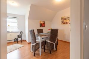 comedor con mesa y sillas en Ferienwohnung am Lagedeich in der Nähe der Husumer Innenstadt en Husum