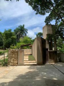 a building with a gate and a stone wall at Cabañas Maya Rue in Palenque