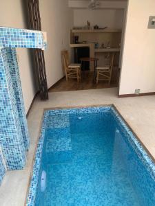 uma piscina com azulejos azuis no chão em Cabañas Maya Rue em Palenque