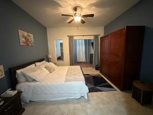 - une chambre avec un lit et un ventilateur de plafond dans l'établissement Tierra Del Sol...OCEAN FRONT GOLF AND TENNIS RESORT CONDO, à Palm-Eagle Beach