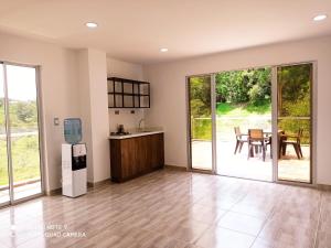 a living room with a kitchen and a table with chairs at Finca Villa Maru in El Peñol