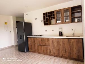 El PeñolにあるFinca Villa Maruのキッチン(黒い冷蔵庫、木製キャビネット付)