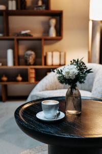 a coffee table with a cup of coffee and a vase of flowers at Hotel Luruna Palacio Larrinaga in Mundaka