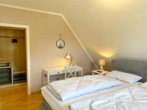 a bedroom with a bed and a table with a clock on the wall at Lohme - Doppelhaushälfte Svantevit 2 in Ranzow in Ranzow