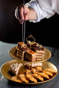 a person drizzling icing onto a plate of food at Casa Bolívar Hotel Museo in Loja