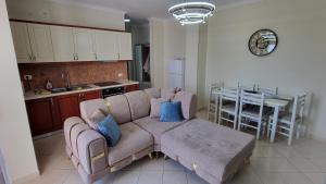 ein Wohnzimmer mit einem Sofa und eine Küche mit einem Tisch in der Unterkunft Ledi Home in Durrës