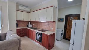 eine Küche mit roten Schränken und einem weißen Kühlschrank in der Unterkunft Ledi Home in Durrës