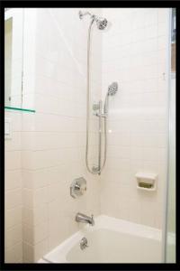 a bathroom with a shower with a tub and a sink at Prime Studio Greenwich Village! in New York