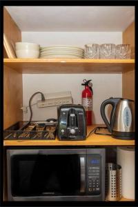 a kitchen with a microwave and a stove and dishes at Prime Studio Greenwich Village! in New York