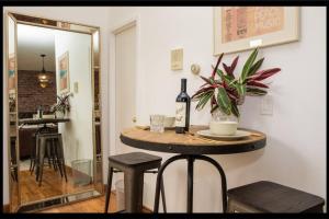 Prime Studio Greenwich Village! في نيويورك: غرفة مع طاولة مع الكراسي ومرآة