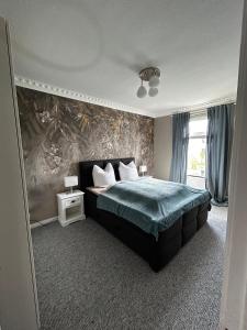 ein Schlafzimmer mit einem Bett mit einer grünen Bettdecke in der Unterkunft Traumhafter Altbaucharme in zentraler Lage in Kiel