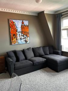 a living room with a couch and a painting on the wall at Traumhafter Altbaucharme in zentraler Lage in Kiel