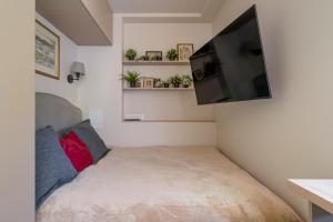 Habitación pequeña con cama y TV de pantalla plana. en Dzintaru 48 studio, en Jūrmala