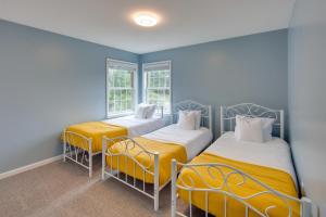 two beds in a room with blue walls and windows at Hummelstown Hideaway with Game Room and Large Yard! in Hummelstown