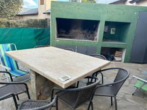 a wooden table and chairs in a yard with a fireplace at Villa emma in Villa General Belgrano