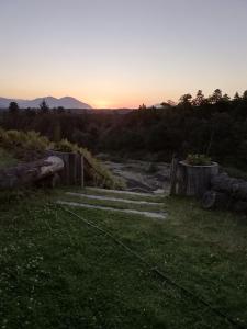 a sunset over a field with a pathway in the grass at Hotel Patagonia Truful y lodge Patagonia truful in Melipeuco