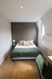 a bedroom with a bed with a green blanket at Hypercentre rue piétonne au calme in Toulouse +6 photos