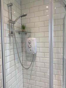 La salle de bains est pourvue d'une douche et de carrelage blanc. dans l'établissement Four Double Bedroom Home - Free parking and Wi-Fi, à Horsforth