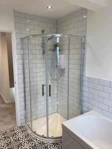a shower with a glass door in a bathroom at Four Double Bedroom Home - Free parking and Wi-Fi in Horsforth