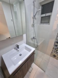 a white bathroom with a sink and a shower at No7 Boutique Apartments in Amman