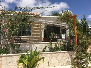 una casa con flores y plantas delante de ella en Beach Villa am Praia de Chaves, Sal Rei, Boa Vista, en Boa Ventura