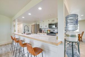 a kitchen with a bar with stools and a large bottle at Tranquil Edgewood Retreat with Patio and Grill! in Edgewood