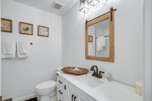 a bathroom with a sink and a toilet and a mirror at Tranquil Edgewood Retreat with Patio and Grill! in Edgewood