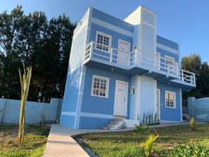 a blue and white house with a balcony at POUSADA BLUE GARDEN in Lages
