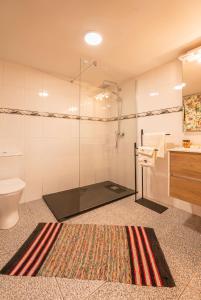 a bathroom with a shower and a toilet and a rug at Villa Fontes 7 in Ponta Delgada
