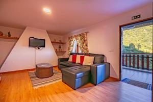 a living room with a couch and a tv at Villa Fontes 7 in Ponta Delgada