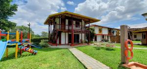 a house with a playground in the yard at Hotel El Gran Chaparral in Calarcá