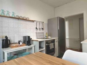 a kitchen with a stainless steel refrigerator and a table at Mini City Apartment in Hannover