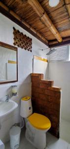 a bathroom with a yellow toilet and a sink at Hotel El Gran Chaparral in Calarcá