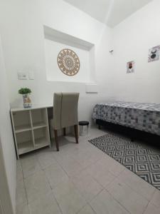 Cette chambre comprend deux lits, un bureau et une chaise. dans l'établissement Temporada Paulistana exclusivo para Mulheres, à São Paulo