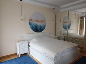 Schlafzimmer mit einem weißen Bett und einem Spiegel in der Unterkunft Rowerowe Wierzchowie in Wierzchowie
