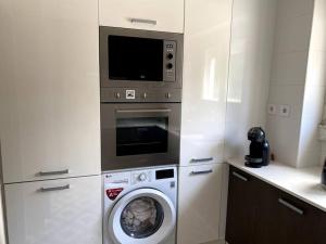 a kitchen with a washing machine and a microwave at T2 Alvalade em Lisboa para 3 Pessoas in Lisbon