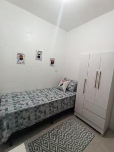 a small bedroom with a bed and a cabinet at Temporada Paulistana exclusivo para Mulheres in Sao Paulo
