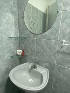 a white sink in a bathroom with a mirror at Pousada Estação do Porto in Porto De Galinhas