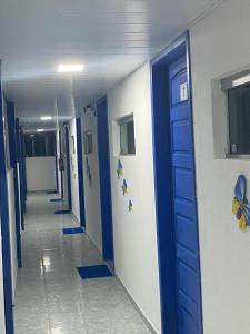 a hallway with a blue door in a hospital at Pousada Estação do Porto in Porto De Galinhas