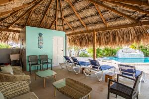 a patio with chairs and tables and a swimming pool at Paradise Apartments - Curacao in Fontein
