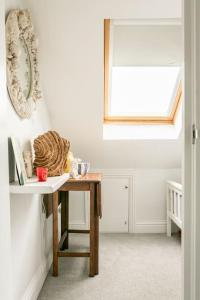 a white room with a table and a window at Hideaway Cottage - seaview room with shared bathroom in Sandgate
