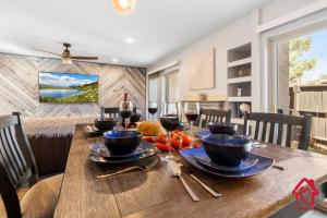 a dining room with a wooden table with wine glasses at The Plaza - An Irvie Home w Summer Pool in Albuquerque