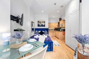 eine Küche und ein Wohnzimmer mit einem Tisch und Stühlen in der Unterkunft Immaculate 1-Bed Studio in London in London