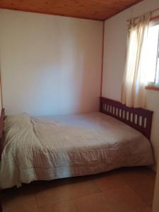 - une chambre avec un lit dans une pièce dotée d'une fenêtre dans l'établissement Hostel Alfa, à San Marcos Sierras