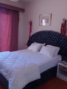 Schlafzimmer mit einem großen weißen Bett mit einem schwarzen Kopfteil in der Unterkunft Almorqqabat Rooms in Dubai