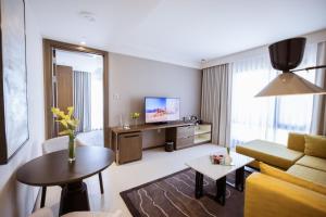 ein Wohnzimmer mit einem Sofa, einem TV und einem Tisch in der Unterkunft Almorqqabat Rooms in Dubai