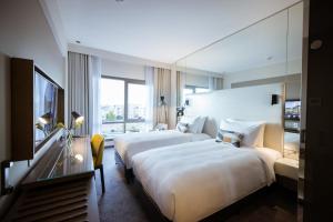 ein Hotelzimmer mit 2 Betten und einem Fenster in der Unterkunft Almorqqabat Rooms in Dubai