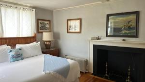 um quarto com uma cama e uma lareira em Cliff Lodge em Nantucket